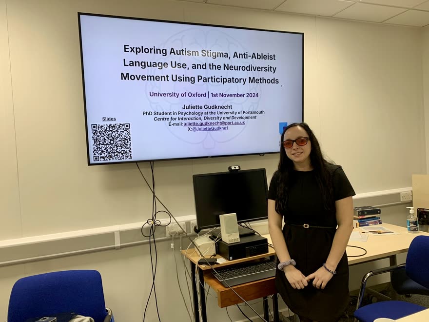Juliette Gudknecht presenting in front of her title slide at the University of Oxford